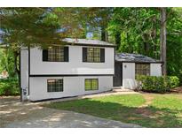 Charming renovated home with a modern color scheme and inviting curb appeal surrounded by mature trees at 1275 Muirforest Way, Stone Mountain, GA 30088
