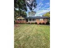 Charming single-story brick home with a well-manicured lawn and mature trees at 1838 Cates Ct, Snellville, GA 30078