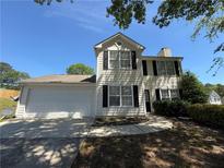 Charming two-story home with a well-maintained lawn, two-car garage, and mature landscaping at 3836 Wexford Dr, Douglasville, GA 30134