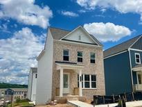 Charming two-story home featuring brick facade and covered front porch under a blue and cloudy sky at 2733 Creek View Nw Ter, Atlanta, GA 30318