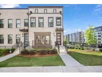 Modern townhome with landscaped front yard and sidewalk leading to the entrance at 1030 Burnside Nw Pl, Atlanta, GA 30318