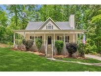 Charming home with a welcoming front porch, lush lawn, and well-maintained landscaping at 3845 Pilgrim Mill Rd, Cumming, GA 30041