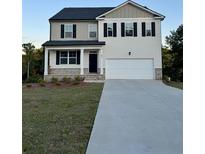 Charming two-story home featuring a well-manicured lawn and a spacious two-car garage with large driveway at 294 Ralph Still Rd, Dacula, GA 30019