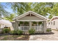Charming bungalow with a welcoming front porch and well-maintained landscaping with black mulch at 2486 Memorial Se Dr, Atlanta, GA 30317
