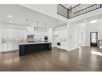 Stunning kitchen boasts a large island, stainless steel appliances, and ample white cabinetry at 6660 Wallace Farms Dr, Cumming, GA 30028