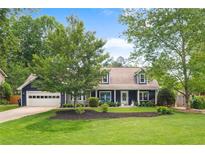 Charming home featuring a well-maintained lawn, lush trees, and a welcoming exterior with a two-car garage at 209 Hearthstone Reach, Peachtree City, GA 30269
