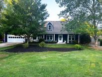 Charming home featuring a well-manicured front yard, attached garage, and inviting front porch at 209 Hearthstone Reach, Peachtree City, GA 30269