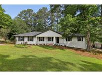 Charming one story home featuring a manicured front yard and a classic white painted brick exterior at 5421 Brownlee Rd, Stone Mountain, GA 30087