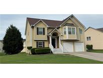 Traditional two-story home features a two-car garage, brick-accented entrance, manicured lawn and decorative trim work at 51 Freedom Ne Dr, Cartersville, GA 30121