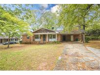 Charming single-story brick home with a covered front porch and a stone walkway at 1443 Snapfinger Rd, Decatur, GA 30032