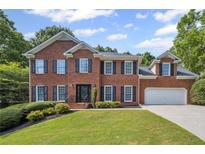 Charming two-story brick home with a well-manicured lawn, complemented by dark shutters at 2350 Twelvestones Dr, Roswell, GA 30076