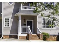 Charming home exterior with a black front door, hanging plants, and brick steps at 78 Crumley Se St, Atlanta, GA 30312