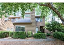 Inviting townhouse featuring a neutral color, a chimney, and lush landscaping at 1606 Parkaire Xing # 1606, Marietta, GA 30068