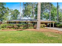 Charming brick home with lush landscaping and a covered carport, offering curb appeal and convenience at 561 Sybil Se Ln, Marietta, GA 30067
