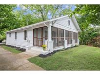 Charming white home featuring a screened-in porch, perfect for relaxing outdoors at 1591 Jonesboro Se Rd, Atlanta, GA 30315