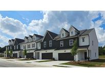 Charming new construction townhomes featuring modern farmhouse designs with single car garages and manicured lawns at 206 Sharon Ln, Loganville, GA 30052