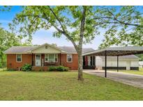 Charming brick home with well-maintained lawn, covered carport, and inviting front porch at 7783 Cantrell Rd, Douglasville, GA 30135