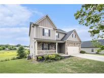 Charming two-story home with stone accents, a front porch, manicured lawn, and an attached two-car garage at 13 Cottage Nw Walk, Cartersville, GA 30121