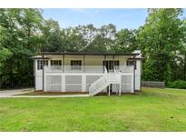 Charming home with a white lattice-covered porch and a well-maintained front yard surrounded by lush trees at 4170 Maroney Mill Rd, Douglasville, GA 30134