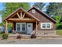Charming one-story home with wood siding, covered porch, brick foundation, and beautifully landscaped yard at 3049 Highway 411 Ne, White, GA 30184