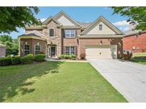 Charming two-story home with brick and stone exterior, well-manicured lawn, and a two-car garage at 4590 Hastings Dr, Cumming, GA 30041