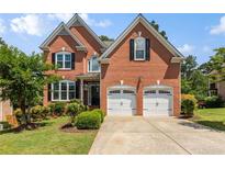 Charming two-story brick home with a well-manicured lawn and a two-car garage at 210 Wentworth Ter, Alpharetta, GA 30022