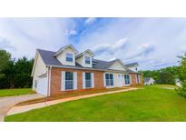 Charming two-story home with brick accents, dormer windows, and well-manicured lawn at 213 Whistle Way, Locust Grove, GA 30248