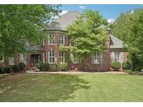 Charming brick home with lush green lawn and mature trees in a desirable neighborhood at 3235 Munsey Ct, Cumming, GA 30041