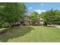 Beautiful brick home with lush green lawn and mature trees, perfect for serene suburban living at 3235 Munsey Ct, Cumming, GA 30041