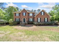 Traditional two-story brick home featuring black shutters and a well-manicured lawn at 5247 Hayden Farms Dr, Powder Springs, GA 30127