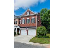 Charming brick townhouse with a two-car garage, black shutters, and well-maintained landscaping at 5605 Waters Edge Trl, Roswell, GA 30075