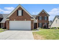 Charming brick home showcasing a well-maintained lawn, two car garage, and classic architectural details at 725 Windsor Place Sw Cir, Grayson, GA 30017