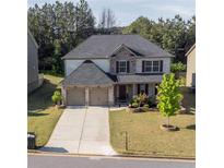 Charming two-story home featuring a two-car garage, well-maintained lawn, and attractive stone and brick accents at 4750 Sabino Bnd, Cumming, GA 30040