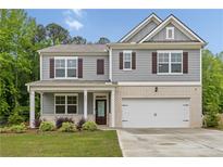 Two-story home features gray siding, brick accents, and a two-car garage at 4827 Golden Finch Ln, Powder Springs, GA 30127