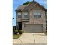 Charming two-story home featuring brick and siding exterior and two car garage at 11813 Lovejoy Crossing Blvd, Hampton, GA 30228