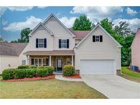 Charming two-story home with a well-manicured lawn, black shutters, and an attached two car garage at 2725 Sedgeview Way, Buford, GA 30519