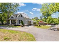 Charming gray home features a metal roof, covered front porch and a long driveway at 527 Main St, Suwanee, GA 30024