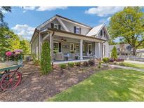 Charming gray two-story home featuring a covered front porch, manicured landscaping, and inviting curb appeal at 527 Main St, Suwanee, GA 30024