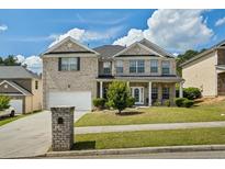 Beautiful two-story brick home featuring a manicured front yard and inviting entrance at 7328 Vigo Dr, Lithonia, GA 30058