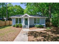 Charming single-story home features a beautifully landscaped front yard with mature trees at 1314 Arkwright Se Pl, Atlanta, GA 30317