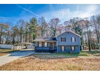 Charming two-story home with a carport and a well-maintained front yard at 1355 Compton Woods Dr, Loganville, GA 30052
