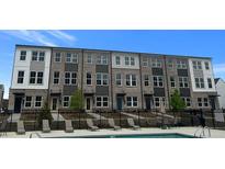 View of stylish townhomes near a community pool and lounge area on a sunny day at 2672 Brookview Nw Ln, Atlanta, GA 30318
