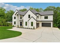 Stunning two-story home with white brick, black trim, a large driveway, and mature landscaping at 2977 N Bogan Rd, Buford, GA 30519