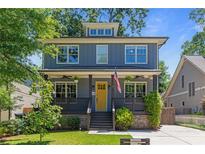 Charming two-story home featuring a welcoming porch with an American flag and a well-manicured front yard at 259 Sisson Ne Ave, Atlanta, GA 30317
