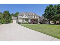 Beautiful two-story home featuring a long driveway, well-manicured lawn, and lovely landscaping at 3735 Duckcove Way, Cumming, GA 30041