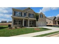 Charming two-story home with brick facade, landscaped yard, and a two-car garage at 1107 Kingston Hill Dr, Loganville, GA 30052