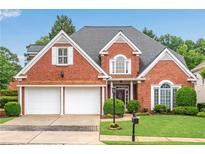 Charming brick home featuring a two-car garage, manicured lawn, and mature trees offering curb appeal at 350 Declaire Ne Way, Marietta, GA 30067