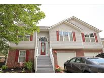 Charming two-story home featuring gray siding, brick accents, red shutters, and an inviting front entrance with a glass paneled door at 116 Remington Place Blvd, Dallas, GA 30157