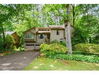 Charming home nestled among lush trees with a two-car garage and inviting front yard at 2261 Ravenwood Trl, Marietta, GA 30066