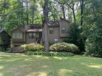 Two-story home with neutral siding and lush landscaping, nestled among mature trees at 2261 Ravenwood Trl, Marietta, GA 30066